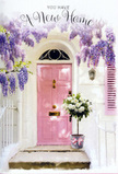 The photograph shows a front step transformed into a quiet celebration that feels right at home in Beckton, where contemporary living often meets small, thoughtful details. The focal point is a pastel pink front door, its colour gentle and soothing, with a smooth finish that subtly reflects the natural light typical of a mild East London afternoon. Around the sides and arching above, wisteria flourishes, its vines disappearing out of frame as they send down cascades of lavender and lilac blooms. These flower clusters hang in overlapping layers, creating the sense of a soft, floral curtain that frames the entrance. Behind them, the whitewashed wall provides a clean, bright backdrop, its slightly textured surface catching stray shadows that dance lightly across the paint. To one side of the door, a softly painted shutter echoes the pink tones, bringing the composition into a harmonious pastel balance. At the doorstep itself, a grey metal bucket has been placed with deliberate care. Inside, a lavish arrangement of white and cream roses fills the container, each bloom lush and rounded, with velvety petals that appear almost cloud-like. Fresh green foliage threads between them, adding small arcs of colour and shaping the bouquet so it looks full and natural rather than rigid. Around the bucket, a pale pink ribbon is tied into a loose bow, its satin tails resting on the stone step like a delicate signature of celebration. The light filtering through the wisteria casts faint, lacy patterns across the threshold, suggesting a gentle breeze and adding depth to the image. Overall, the scene radiates calm excitement and tenderness, evoking the feeling of arriving at a new home in Beckton, greeted by flowers that quietly express love, hope, and a warm welcome at the door.